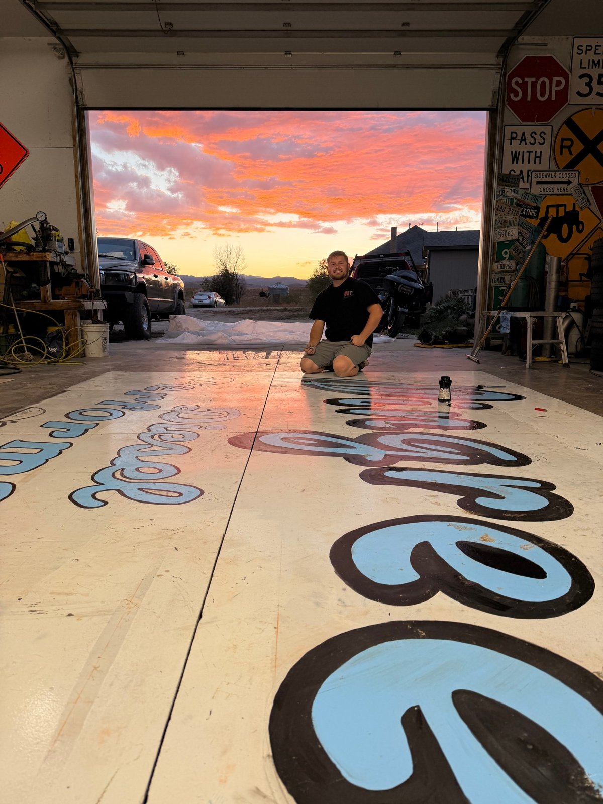 Painted Pingree lettering on the shop floor, with sunset through the doorway.